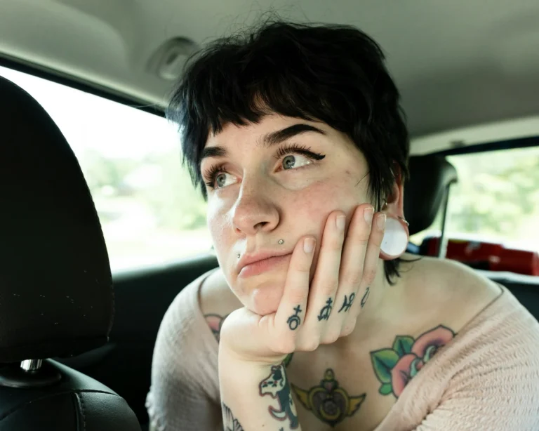 photo - a woman in a car thinking about how to come up with tattoo ideas