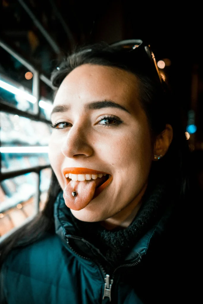photo - a happy woman sticking her tongue out showing her fully healed tongue piercing