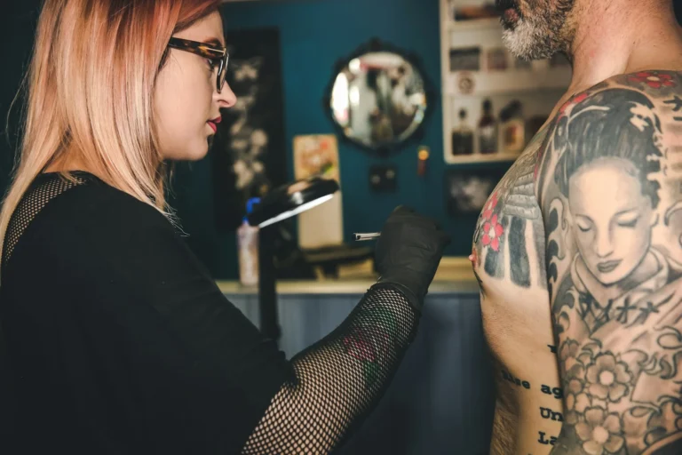 photo - a tattoo artist working on applying chest tattoo ideas for guys