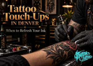 Tattoo touch up in Denver feature image for Mantra Tattoo showing a professional artist refreshing faded ink with a tattoo machine in a premium studio setting.